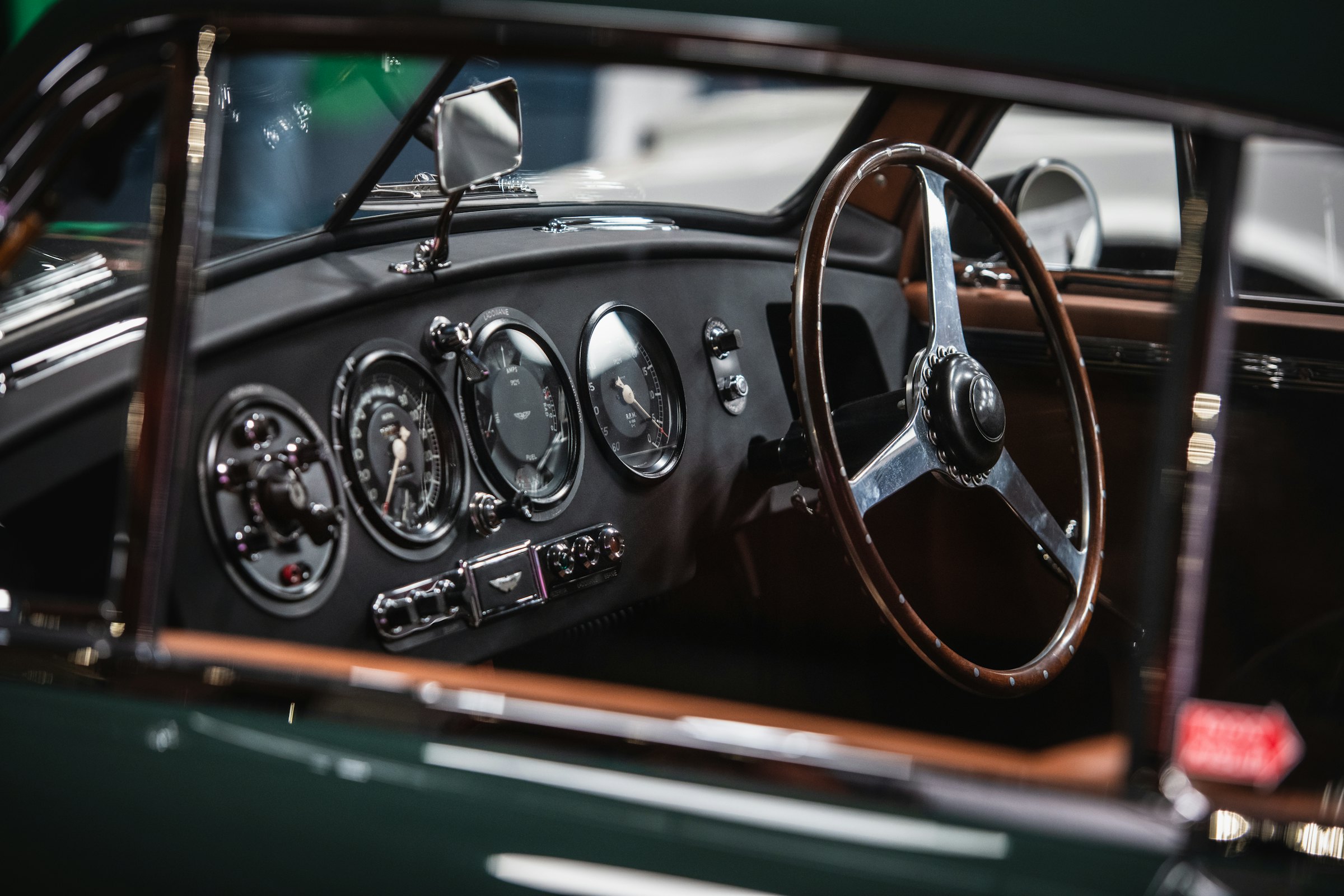 Wood-rimmed steering wheel and chrome gauges of a classic sports car